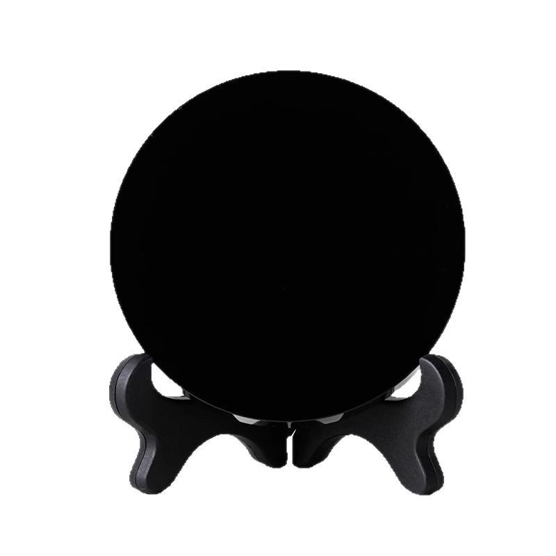 Prirodni obsidijan disk s glatkom crnom kristalnom površinom, ogledalo u obliku diska na crnoj podlozi