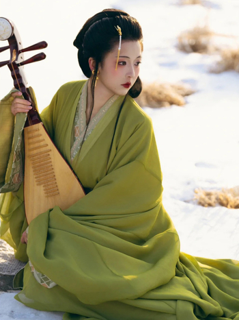 Zelena Hanfu haljina u stilu Proljeće–Jesen/Ratničkih dinastija, s ravnim rubom, preklopnim ovratnikom i dugim šlepom; inspirirano rekonstrukcijom grobnice Ma Shan Chu, tradicionalni pozorišni kostim