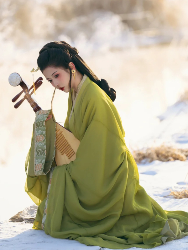 Zelena Hanfu haljina u stilu Proljeće–Jesen/Ratničkih dinastija, s ravnim rubom, preklopnim ovratnikom i dugim šlepom; inspirirano rekonstrukcijom grobnice Ma Shan Chu, tradicionalni pozorišni kostim