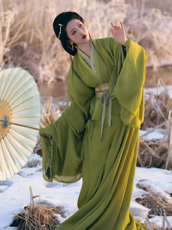 Zelena Hanfu haljina u stilu Proljeće–Jesen/Ratničkih dinastija, s ravnim rubom, preklopnim ovratnikom i dugim šlepom; inspirirano rekonstrukcijom grobnice Ma Shan Chu, tradicionalni pozorišni kostim