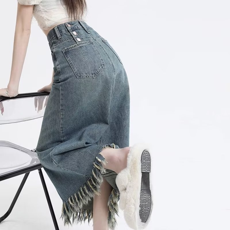 Retro denim suknja visokog struka s prednjim izrezom i resicama, srednje duljine, A-linije kroja.