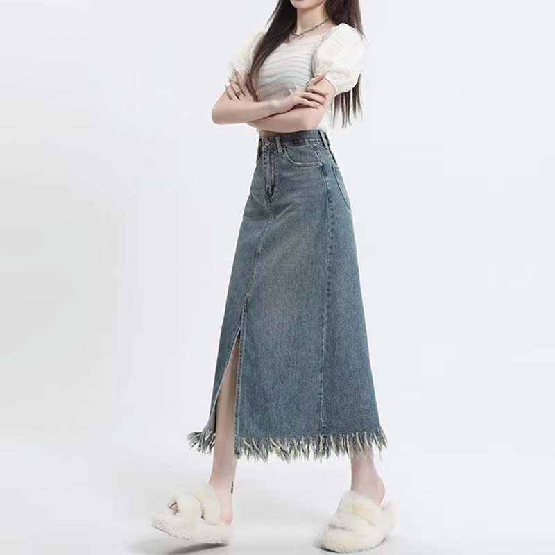 Retro denim suknja visokog struka s prednjim izrezom i resicama, srednje duljine, A-linije kroja.