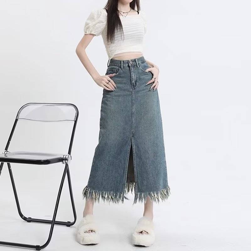 Retro denim suknja visokog struka s prednjim izrezom i resicama, srednje duljine, A-linije kroja.