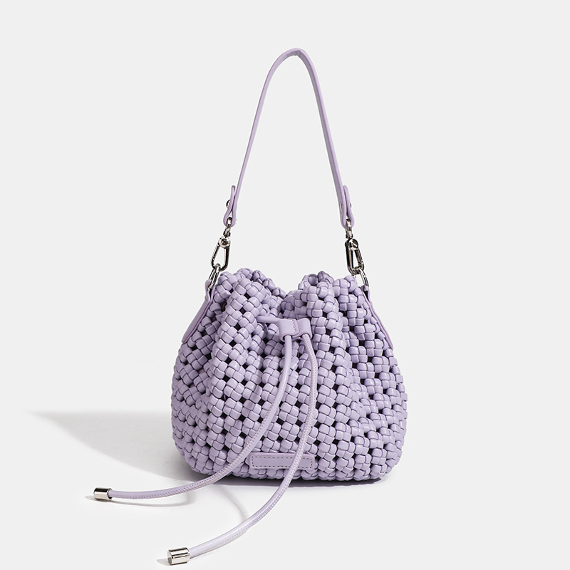 Ručna pletena bucket torbica s vezicom za zatvaranje, svestrana za svakodnevnu upotrebu.