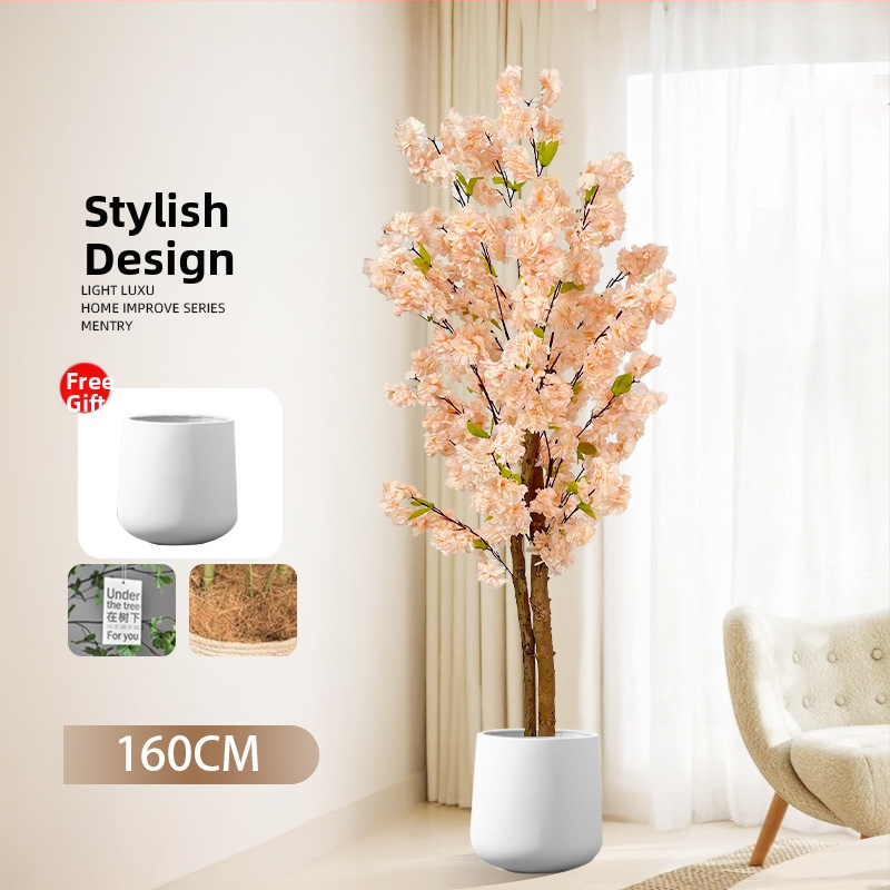 Umelý strom šampaň v kvetináči s umelými broskyňovými kvetmi a zelenou rastlinou – podlahová dekorácia do obývačky.