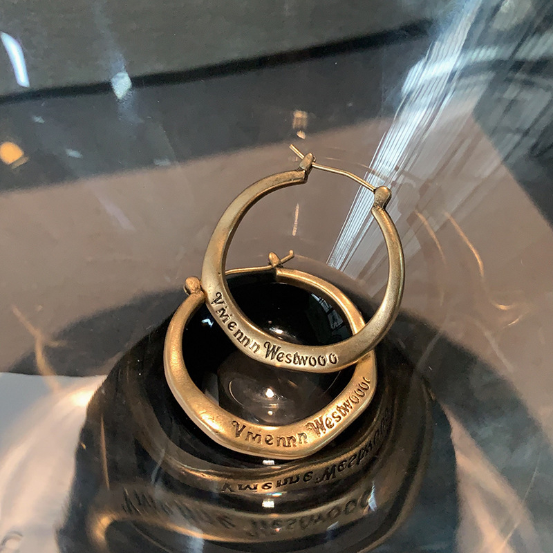 Ženske metalne naušnice s literom u kružnici — minimalističke brončane nijanse, elegantne i svestrane