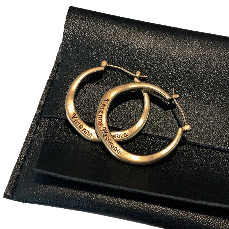 Ženske metalne naušnice s literom u kružnici — minimalističke brončane nijanse, elegantne i svestrane