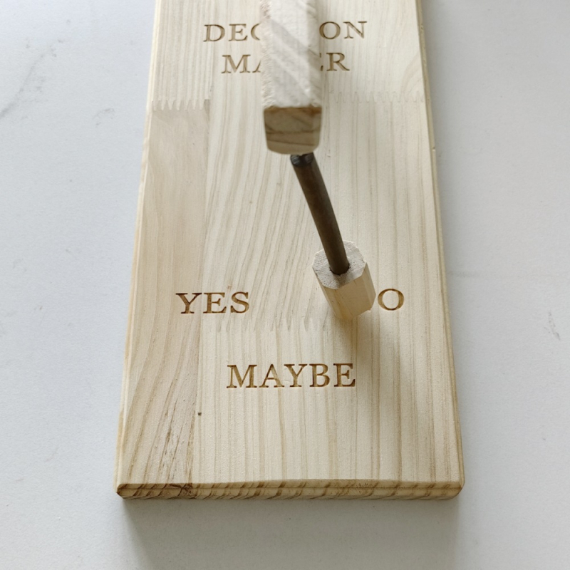 Drveni privjesak s motivom 'Decision Maker'.