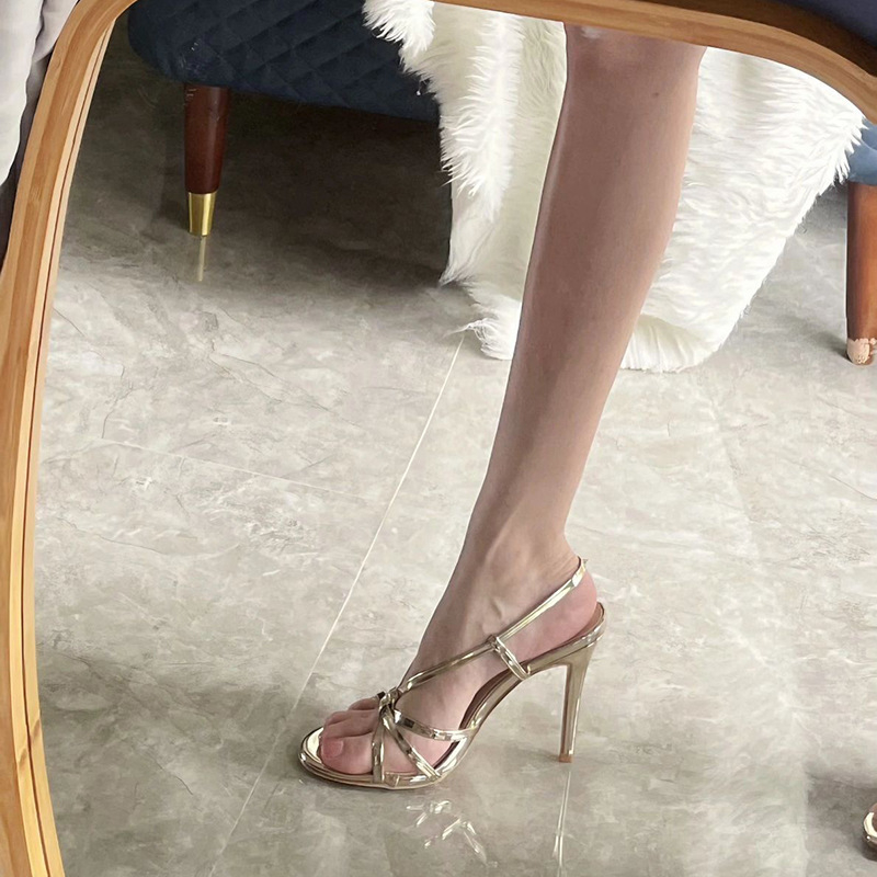 Zlatne ženske sandale s tankim petom i jednim remenom, elegantan stil, ljeto 2025
