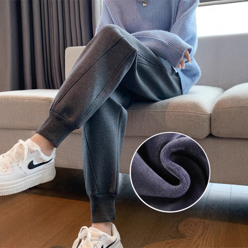 Ženske sportske hlače s fleece podstavom, sive boje, za jesen-zimu, ravni kroj, opuštene nogavice, manžetama pri gležnju, tople i udobne.
