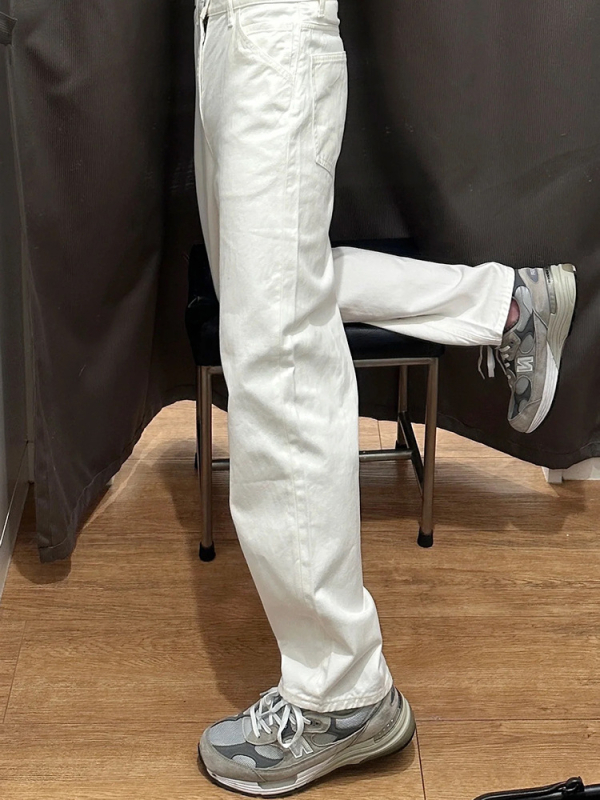 Fehér férfi farmernadrág denimből, enyhén bővülő szár, karcsú, egyenes szabás, utcai stílus.