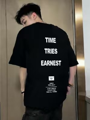 Μαύρο αντρικό T‑shirt με κοντό μανίκι, χαλαρή γραμμή, τύπωμα γραμμάτων και γεωμετρικός σχεδιασμός, δροσερό και άνετο για καθημερινή χρήση το καλοκαίρι.