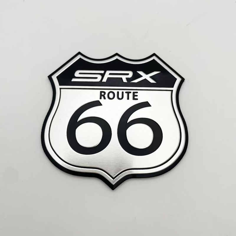 SRX autómatrica, SRX logó, 66-os út matrica, alumíniumötvözet, méret 70x65 mm, karcolások elleni védelem