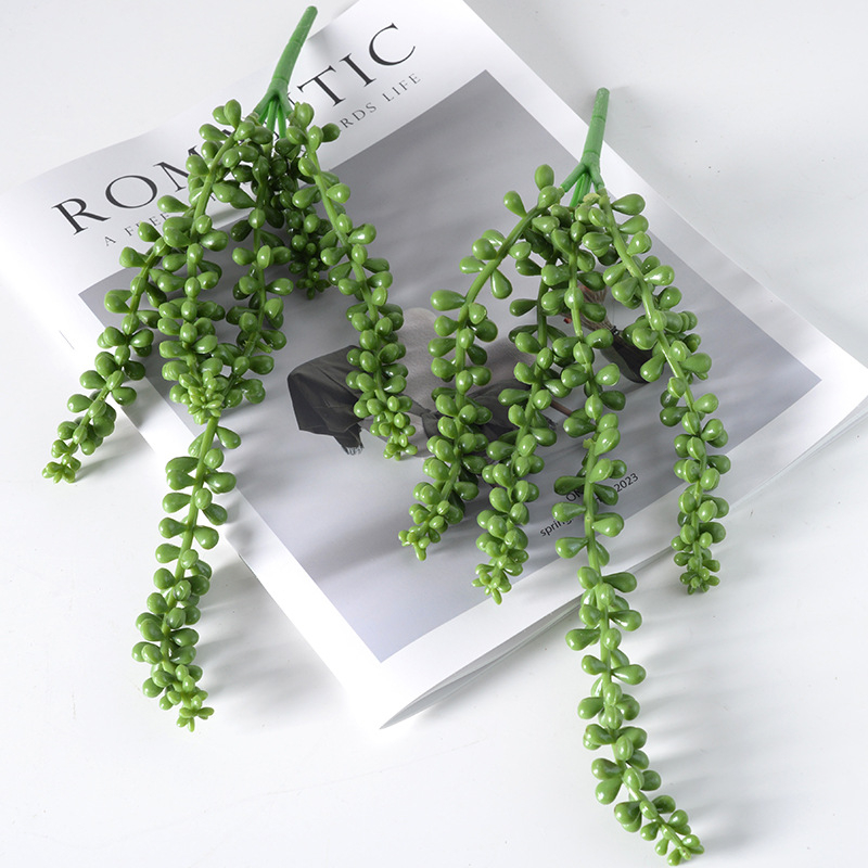 Plantă agățătoare artificială cu aspect suculent și șir de mărgele perlate în ghiveci