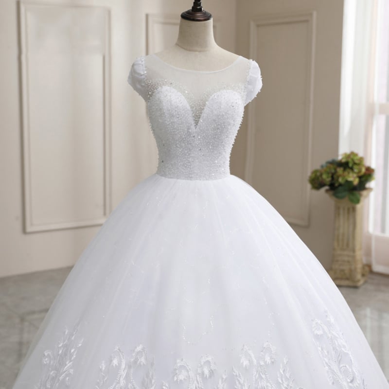 Rochie de mireasă cu tren lung, fără spate, design minimalist, lungime medie, talie la nivel mediu, dantelă în stil pădure, alb de vis