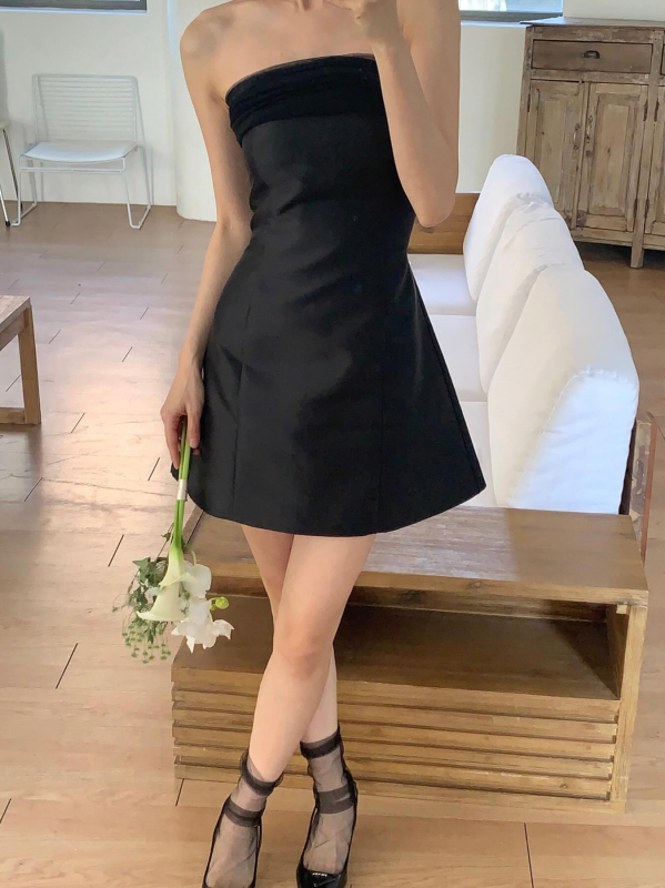 Rochie de seară neagră din satin, scurtă, în stil Hepburn, fără bretele, decolteu pe umeri, funda; eleganță minimalistă de înaltă calitate