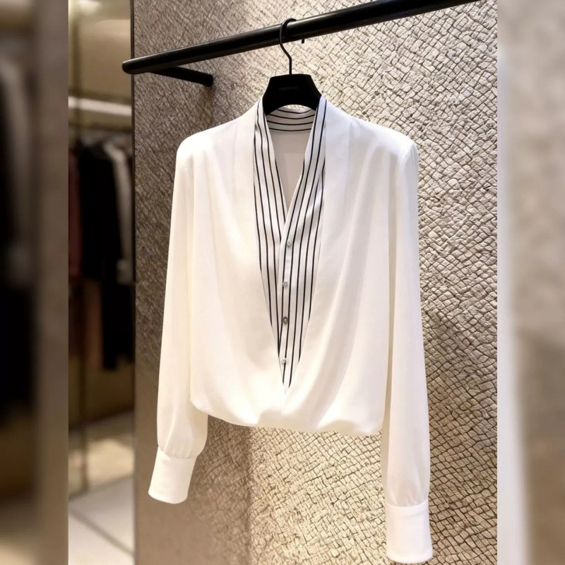 Bluză albă cu dungi, aspect de două piese, pentru ținută casual-office, primăvara 2026, decolteu în V.