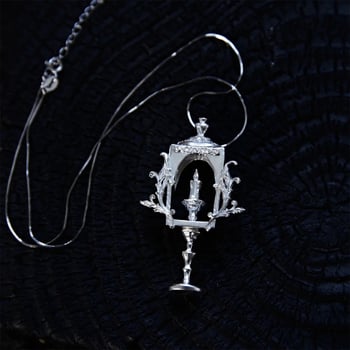 Design original de nișă: colier din cupru în stil gotic, cu motive de lumânare și pahar de vin înalt