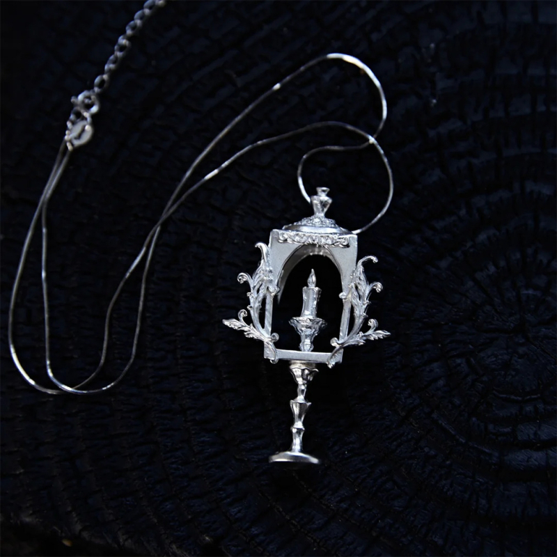 Design original de nișă: colier din cupru în stil gotic, cu motive de lumânare și pahar de vin înalt