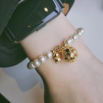Narukvica s privjeskom zlatno obojenim bisernim vrećicom i privjeskom zeko, otvoreni dizajn