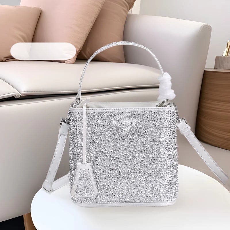 Geantă bucket nouă, primăvară-vară 2025, marca P, cu logo triunghi inversat și strasuri diamantate, purtată pe umăr sau crossbody