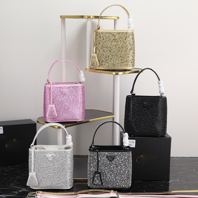 Geantă bucket nouă, primăvară-vară 2025, marca P, cu logo triunghi inversat și strasuri diamantate, purtată pe umăr sau crossbody