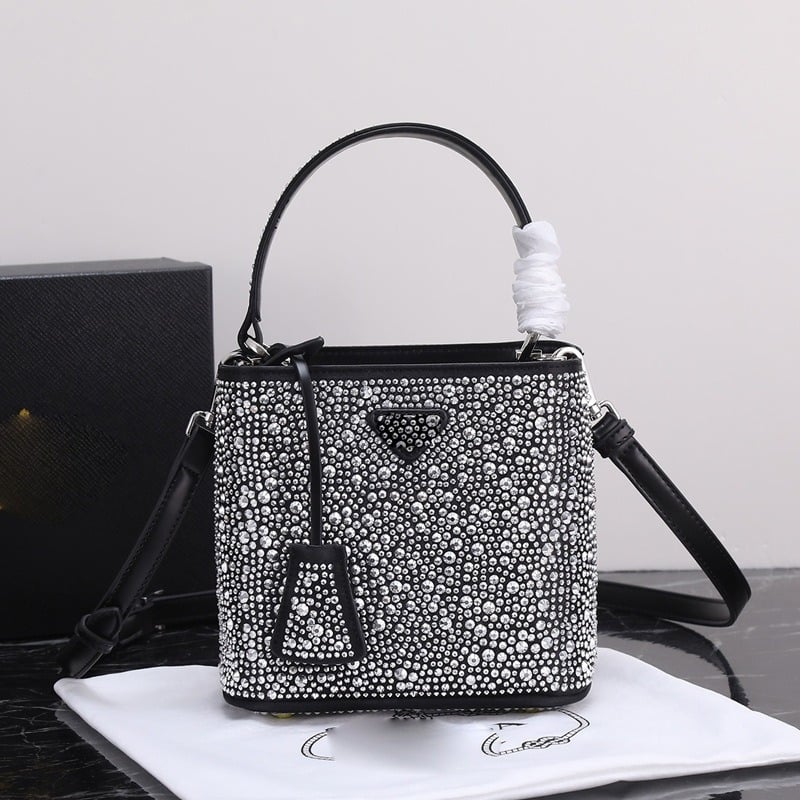 Geantă bucket nouă, primăvară-vară 2025, marca P, cu logo triunghi inversat și strasuri diamantate, purtată pe umăr sau crossbody