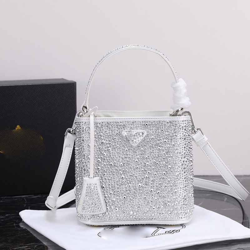 Geantă bucket nouă, primăvară-vară 2025, marca P, cu logo triunghi inversat și strasuri diamantate, purtată pe umăr sau crossbody
