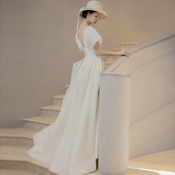 Rochie de mireasă în stil francez, satin alb, lungă, fără mâneci, decolteu adânc în V, inspirată de Hepburn pentru mici siluete, retro pentru ședințe foto de călătorie.