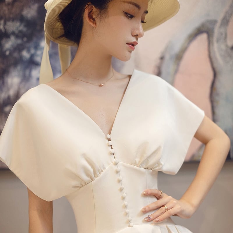 Rochie de mireasă în stil francez, satin alb, lungă, fără mâneci, decolteu adânc în V, inspirată de Hepburn pentru mici siluete, retro pentru ședințe foto de călătorie.