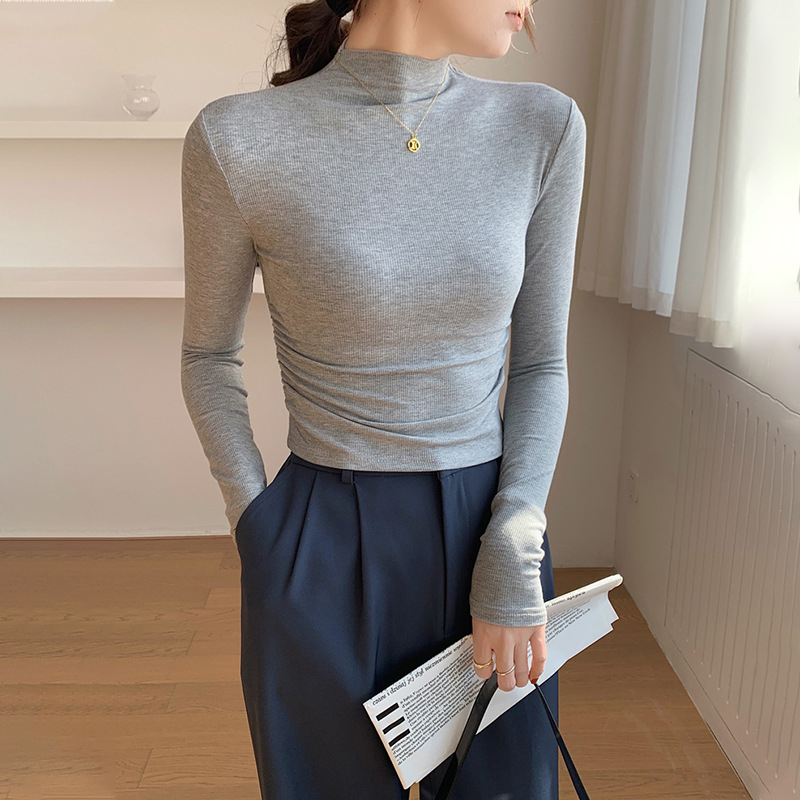 Γυναικεία μακρυμάνικη μπλούζα με λαιμό mock neck, πλισίσεις στον δεξιό ώμο, στενή εφαρμογή και κοντή γραμμή.