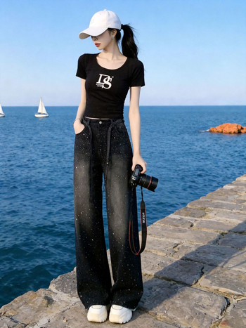 Σετ δύο τεμαχίων για γυναίκες με vintage streetwear: μαύρο T-shirt με εκτύπωση και στρας σε τζιν παντελόνι, casual καλοκαιρινό ντύσιμο.