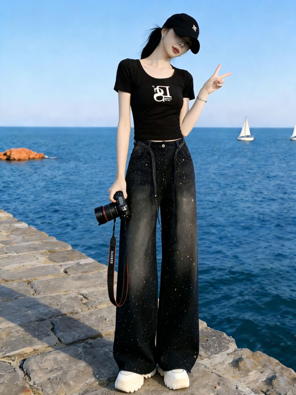 Σετ δύο τεμαχίων για γυναίκες με vintage streetwear: μαύρο T-shirt με εκτύπωση και στρας σε τζιν παντελόνι, casual καλοκαιρινό ντύσιμο.