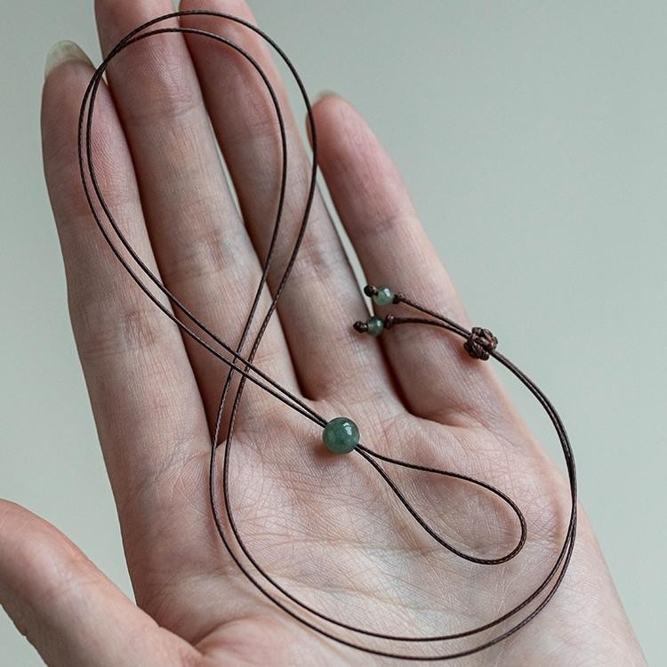 Vékony nyaklánc zsinórral, jáde medállal és gyűrű formájú medállal, fekete bőrzsinórral, minimalist stílus