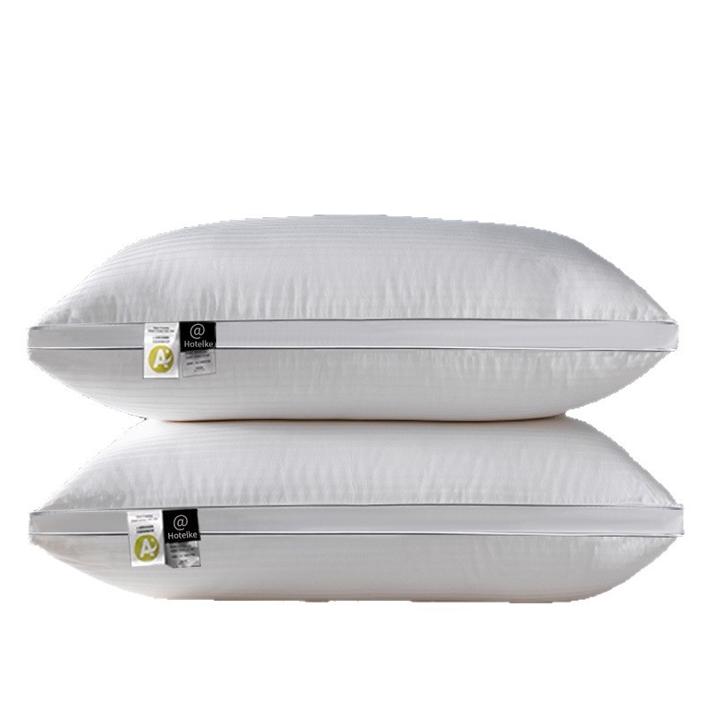 Fehér pamut párna, nagy rugalmasságú, téglalap alakú, satin csíkos dizájn, magasság 12 cm felett, tömeg 3–3,5 kg, töltet poliészter rost