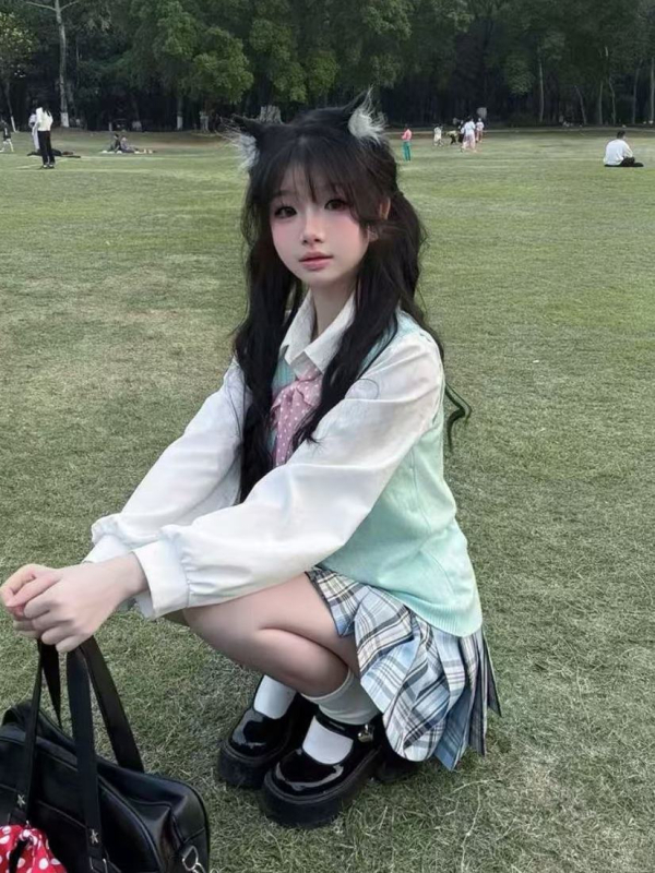 Japán stílusú iskolai együttes: lazán szabott kék kockás szoknya, pulóver-mellény, lányoknak
