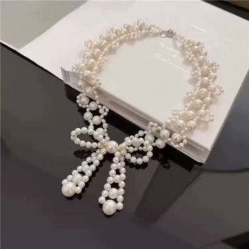 Könnyed luxusú, különleges dizájnú masni nyaklánc műgyöngyökkel, gyengéd, elegáns.