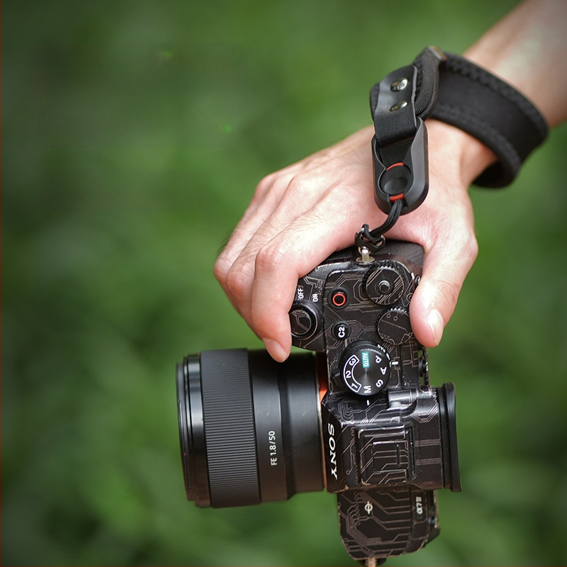 Kameros laikiklis riešui su sustiprintu narų medžiagą, greitai atleidžiama sagtis ir aukštos tvirtumo mikropluošto oda; Modelis 20250526; apkrova iki 50 kg; suderinamas su įvairiomis DSLR ir be veidrodžių kamera