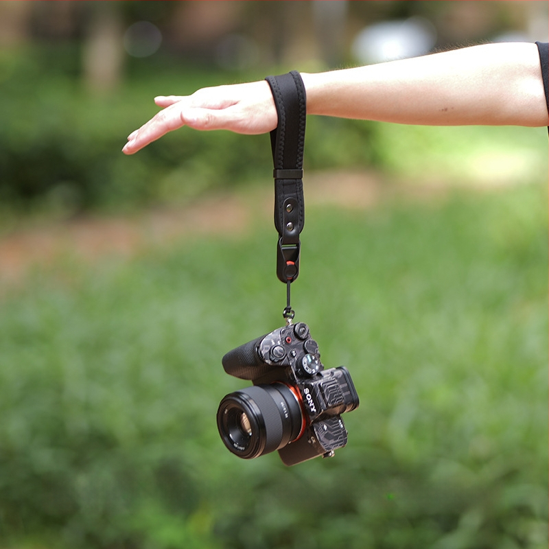 Kameros laikiklis riešui su sustiprintu narų medžiagą, greitai atleidžiama sagtis ir aukštos tvirtumo mikropluošto oda; Modelis 20250526; apkrova iki 50 kg; suderinamas su įvairiomis DSLR ir be veidrodžių kamera