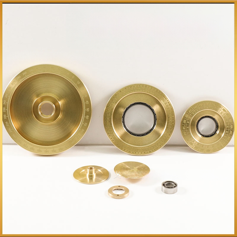 Žalvarinis kompasas ant stalo – daugiasluoksnis aštuonių trigramų motyvas, streso mažinimui skirta pirštų suktuko rankena