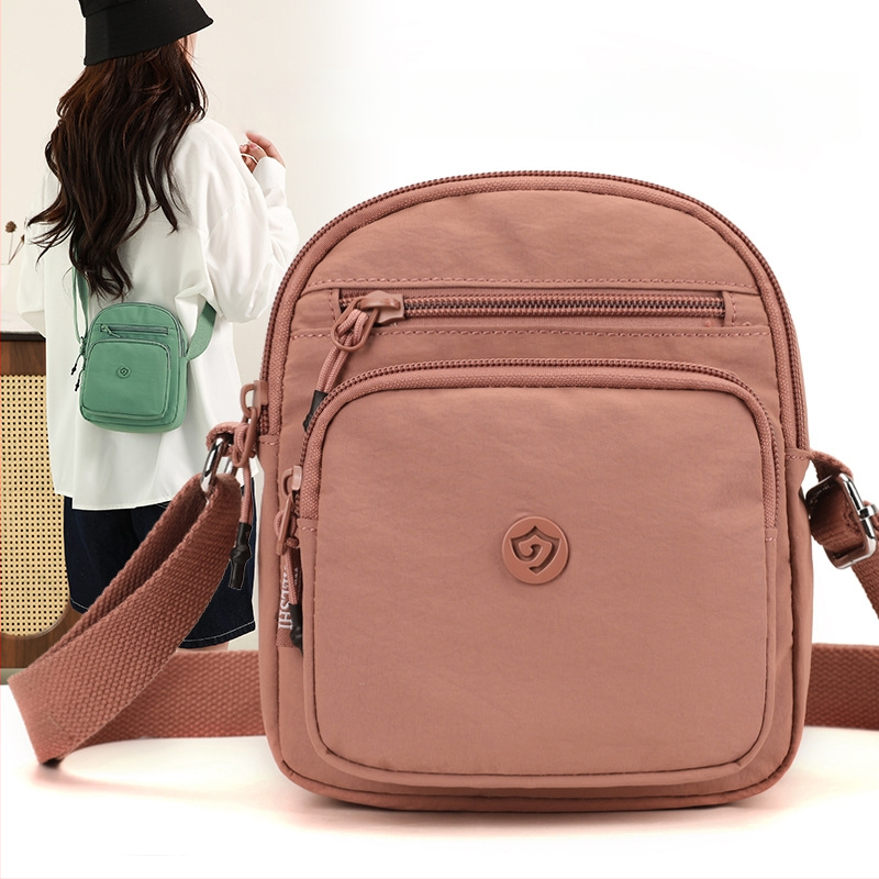 Найлонова кроссбоди чанта с вертикална квадратна форма, цип за затваряне, джоб за мобилен телефон и вътрешен джоб-патч.