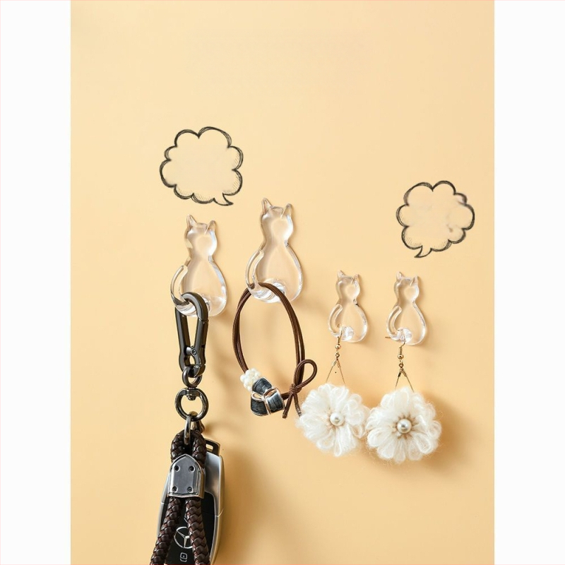 Caurskatāms sveķu kaķa motīva āķis – sienai bez urbšanas, vienkāršs karikatūras stils, maksimālā slodze 0–1 kg, izlaidums 2025