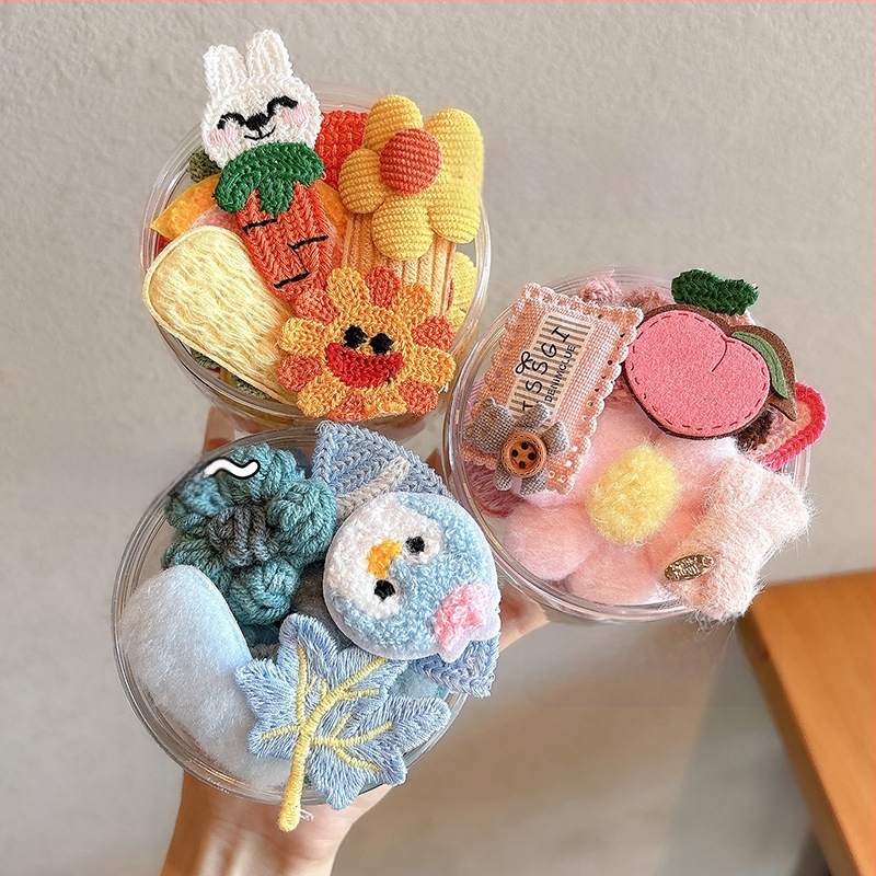 Lastele mõeldud juukseaksessuaaride komplekt — käsitöö kõrval klips lillmotiiviga joonistusstiilis, vanuserühm 3–10 aastat.