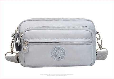 Moteriška crossbody rankinė — kasdienio stiliaus, universalus, lengva, vandeniui atspari nailonas; horizontali kvadratinė forma, užsegimas užtrauktuku, poliesterio pamušalas, viduje užtrauktuko kišenė ir telefono kišenė