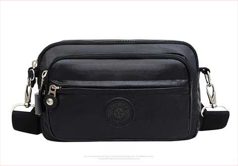 Moteriška crossbody rankinė — kasdienio stiliaus, universalus, lengva, vandeniui atspari nailonas; horizontali kvadratinė forma, užsegimas užtrauktuku, poliesterio pamušalas, viduje užtrauktuko kišenė ir telefono kišenė