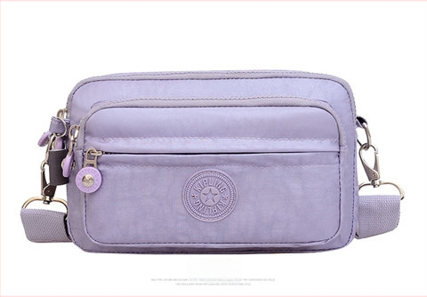 Moteriška crossbody rankinė — kasdienio stiliaus, universalus, lengva, vandeniui atspari nailonas; horizontali kvadratinė forma, užsegimas užtrauktuku, poliesterio pamušalas, viduje užtrauktuko kišenė ir telefono kišenė