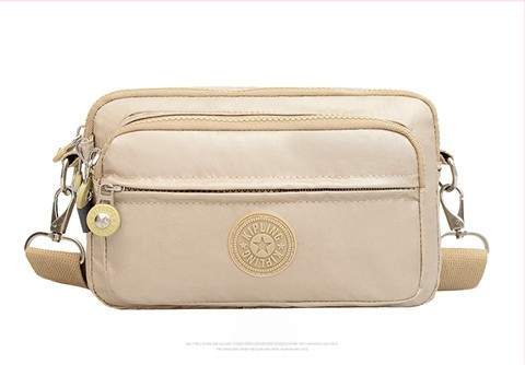 Moteriška crossbody rankinė — kasdienio stiliaus, universalus, lengva, vandeniui atspari nailonas; horizontali kvadratinė forma, užsegimas užtrauktuku, poliesterio pamušalas, viduje užtrauktuko kišenė ir telefono kišenė