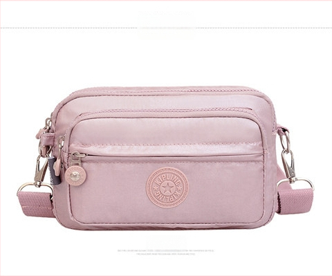 Moteriška crossbody rankinė — kasdienio stiliaus, universalus, lengva, vandeniui atspari nailonas; horizontali kvadratinė forma, užsegimas užtrauktuku, poliesterio pamušalas, viduje užtrauktuko kišenė ir telefono kišenė