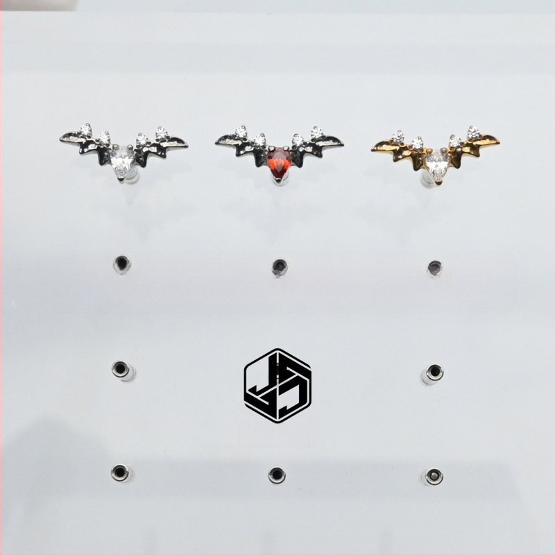 Auskari no F136 implantāta titāna sakausējuma, forma kā bat-vēnijas ūdens pilienam