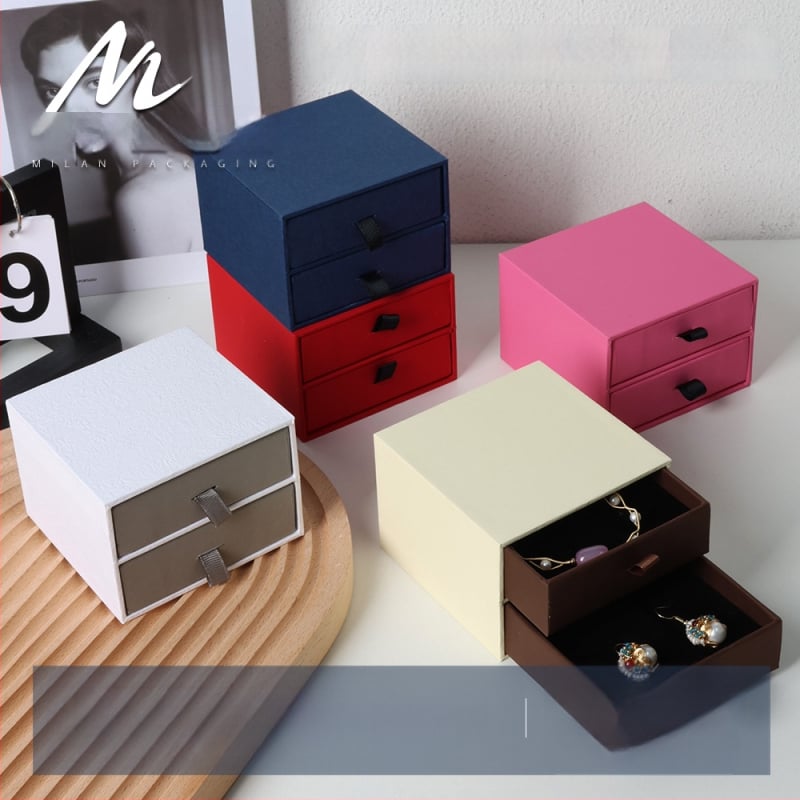Divslāņu juvelierizstrādājumu kastīte ar atvilktnēm; materiāls: papīrs/kartons; iepakojuma veids: kastīte; zīmols: Milan